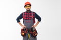 Portrait of happy young indian male construction worker with tool belt isolated on white background