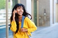 Happy young Indian woman walking with mobile phone and bag Royalty Free Stock Photo