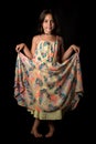 Portrait of happy young little girl holding long colourful dress