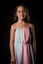 Portrait of happy young little girl holding long colourful dress