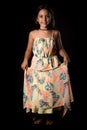 Portrait of happy young little girl holding long colourful dress