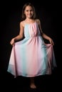 Portrait of happy young little girl holding long colourful dress