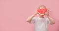 portrait happy young little girl is holding slice of watermelon over colorful pink background Royalty Free Stock Photo