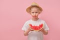 portrait happy young little girl is holding slice of watermelon over colorful pink background Royalty Free Stock Photo