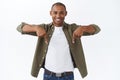 Portrait of happy young male client, african-american man inviting join team, check-out product, pointing fingers down