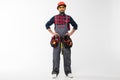 Portrait of happy young indian male construction worker with tool belt isolated on white background