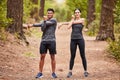 Portrait of a happy young male and female athlete stretching their arms before a run outside in nature. Two fit Royalty Free Stock Photo