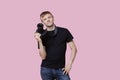 Portrait of a happy young male photographer holding camera over pink background Royalty Free Stock Photo