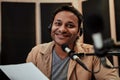 Portrait of happy young male radio host in headphones smiling at camera while talking, broadcasting in studio Royalty Free Stock Photo