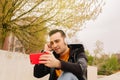 Portrait of a happy young man in the city watching a video on his smartphone or making a video call with his relatives or partner Royalty Free Stock Photo