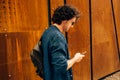 Portrait of happy young man with curly hair using laptop for working online. Smart freelance man chatting online with clients. Royalty Free Stock Photo