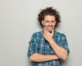 happy man with curly hair folding arms, touching chin and dreaming Royalty Free Stock Photo