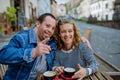 Portrait of happy young man with Down syndrome with his mother sitting at cafe outdoors and talking. Royalty Free Stock Photo