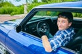 Portrait of happy young man driving blue car Royalty Free Stock Photo