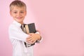 Profile portrait of happy young man holding books in his hands. Back to school. while standing against pink background. place for Royalty Free Stock Photo