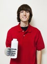 Portrait of a happy young man holding bottle with prosthetic hand over gray background Royalty Free Stock Photo