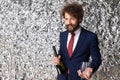 Portrait of happy young man holding champagne bottle and glasses Royalty Free Stock Photo