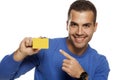 Portrait of happy young man, holding empty credit card on white Royalty Free Stock Photo