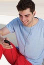 Portrait of a happy young man listening to music on his mobile phone Royalty Free Stock Photo