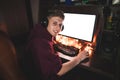 Portrait of a happy young man playing video games at night at home, looking into the camera and smiling Royalty Free Stock Photo