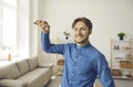 Portrait of happy young man smiling and showing us keys to his new house or flat Royalty Free Stock Photo