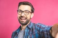 Portrait of a happy young man taking a selfie photo isolated over pink background. Close-up Royalty Free Stock Photo