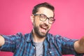 Portrait of a happy young man taking a selfie photo isolated over pink background. Close-up Royalty Free Stock Photo