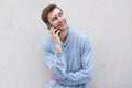 Happy young man talking with mobile phone by wall Royalty Free Stock Photo