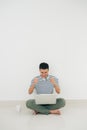 Portrait of a happy young man using laptop and celebrating success  over white background Royalty Free Stock Photo