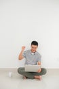 Portrait of a happy young man using laptop and celebrating success isolated over white background Royalty Free Stock Photo