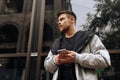 Portrait of happy young man walking on the street and looking aside while talking by his phone Royalty Free Stock Photo