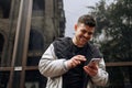 Portrait of happy young man walking on the street and looking aside while talking by his phone Royalty Free Stock Photo