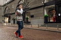 Portrait of happy young man walking on the street and looking aside while talking by his phone Royalty Free Stock Photo