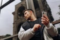 Portrait of happy young man walking on the street and looking aside while talking by his phone Royalty Free Stock Photo