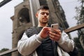 Portrait of happy young man walking on the street and looking aside while talking by his phone Royalty Free Stock Photo