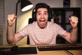 Portrait of happy young man yelling while playing video games on Royalty Free Stock Photo