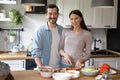 Portrait of happy young married couple cooking together in kitchen. Royalty Free Stock Photo