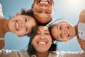 Portrait of a happy young mixed race family standing together in huddle smiling and looking down at camera on a sunny Royalty Free Stock Photo