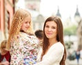 Happy young mother holding her daughter in her arms in city Royalty Free Stock Photo