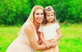 Portrait of happy young mother with little girl baby walking outdoors in summer park Royalty Free Stock Photo