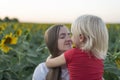 Portrait of happy young mother and little son on field of sunflowers background. Tenderness and trust Royalty Free Stock Photo