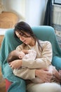 Portrait of happy young mother sitting with baby son in armchair Royalty Free Stock Photo