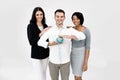 Portrait of happy young multiethnical businesspeople, African and Caucasian women, Caucasian man holding earth globe Royalty Free Stock Photo