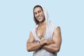 Portrait of happy young muscular man wearing hooded jacket standing against colored background Royalty Free Stock Photo