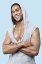 Portrait of happy young muscular man wearing hooded jacket standing against colored background Royalty Free Stock Photo