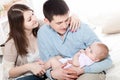 Portrait of happy young parents with baby in the bed at home Royalty Free Stock Photo