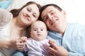 Portrait of happy young parents with baby in the bed at home Royalty Free Stock Photo