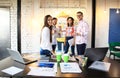 Portrait of happy young people in a meeting looking at camera and smiling. Young designers working together on a