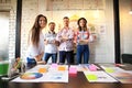 Portrait of happy young people in a meeting looking at camera and smiling. Young designers working together on a Royalty Free Stock Photo