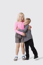 Portrait of happy young siblings hugging over white background Royalty Free Stock Photo